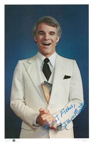 A photo of Steve Martin with a fish head sticking out of his jacket, along with the signature that reads 'Best Fishes, Steve Martin'